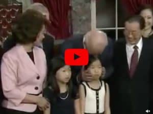 Joe Biden strokes the hair of a young girl and kisses her on the head